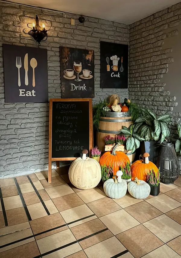 Wejście do Verony z tablicami Eat, Drink, Cook, tablicą kredową i jesiennymi dyniami